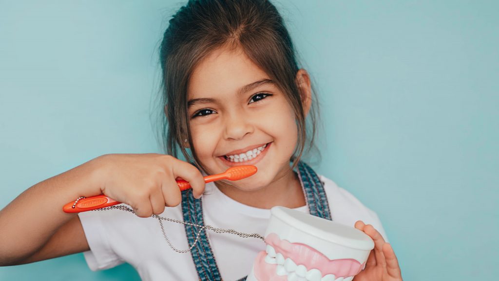 Mädchen putzt Zähne beim Kinderzahnarzt